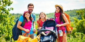 Family with travel gear enjoying a sunny outdoor adventure.